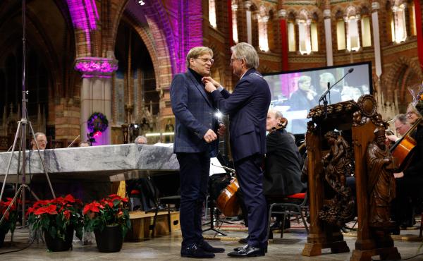 Luuc Jonker, links, kreeg in een volle Vituskerk de gemeentespeld van burgemeester Gerhard van den Top opgespeld
