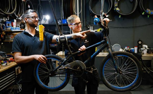 Twee fietsmonteurs repareren een fiets