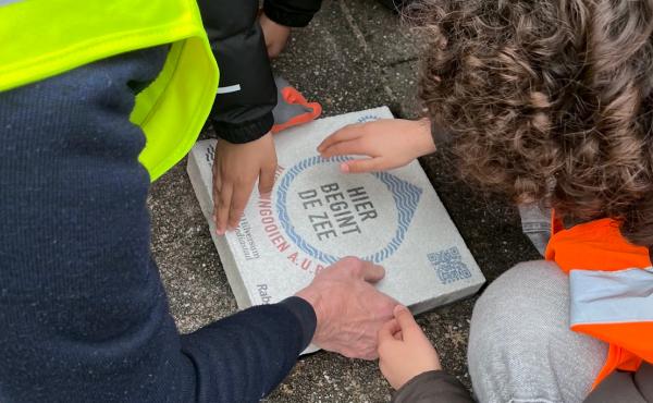Leerlingen en de rotary leggen de eerste ‘Hier begint de zee’-tegel 